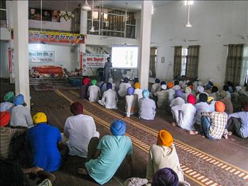 The august audience listening with pin drop silence in presence of Sri Guru Granth Sahib Ji.
