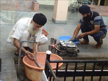 The delegates performing the sewa of washing utensils of the Pingalwara patients.