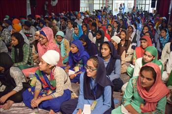 Student at conference listening to speakers with keen interest